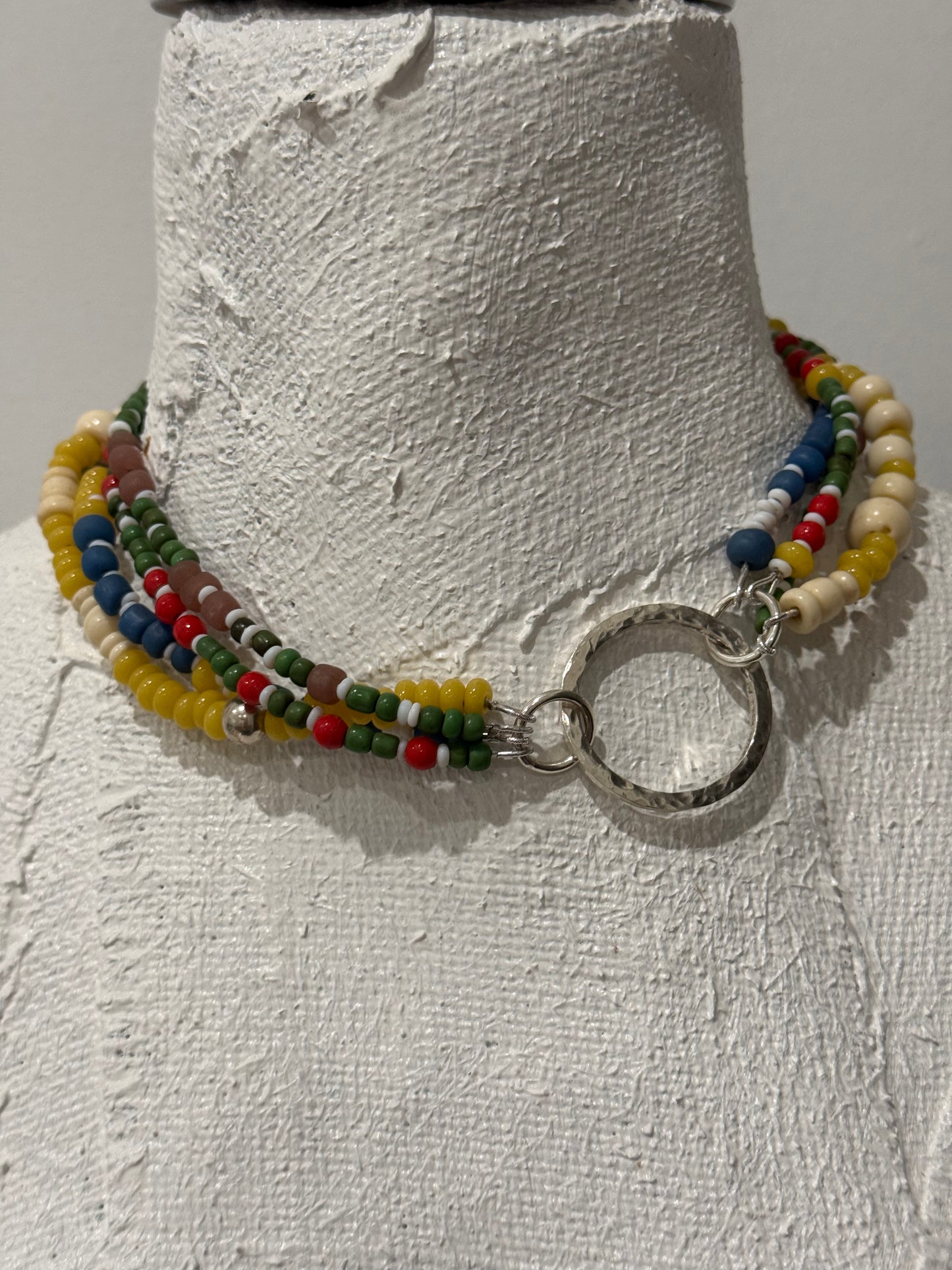 Multi coloured/multi strand with beaten sterling silver circle link to be worn off centre