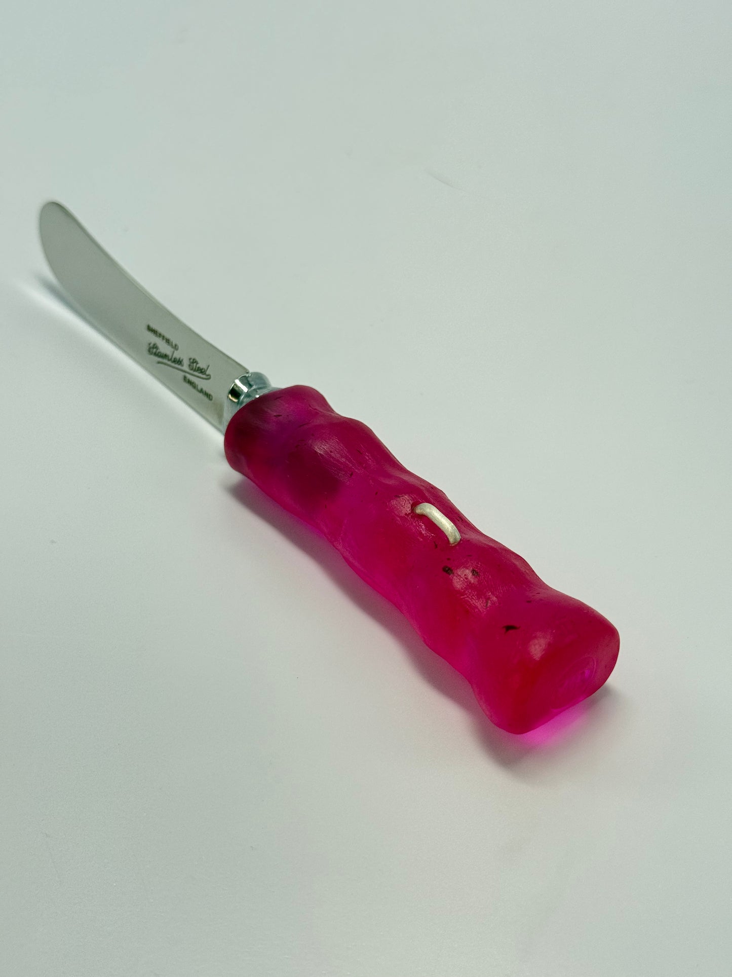 Cheese knife - Strawberry Red resin - irregular shaped handle with silver staple insert