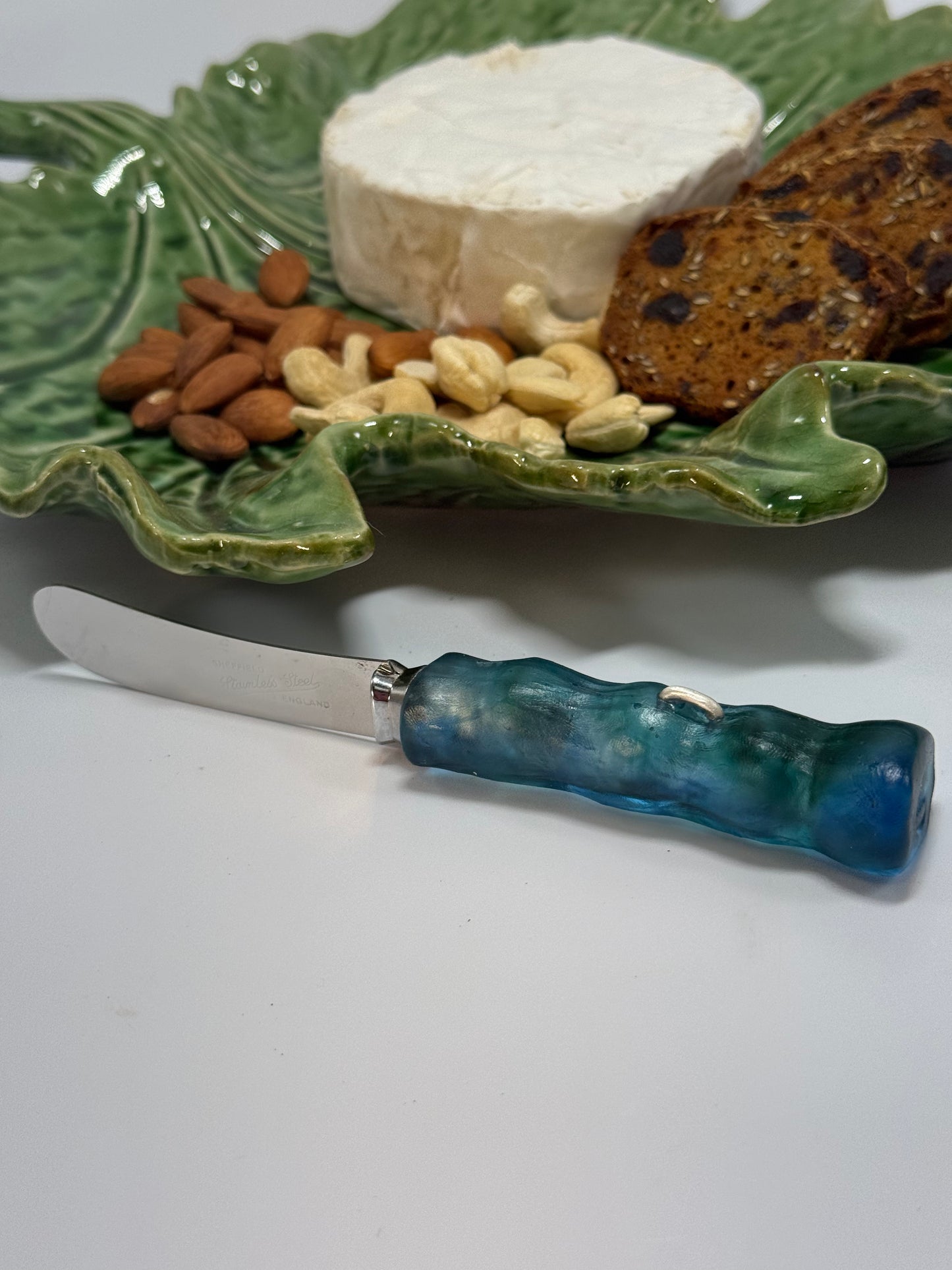 Cheese knife - Translucent blue/green resin - irregular shaped handle with silver staple insert