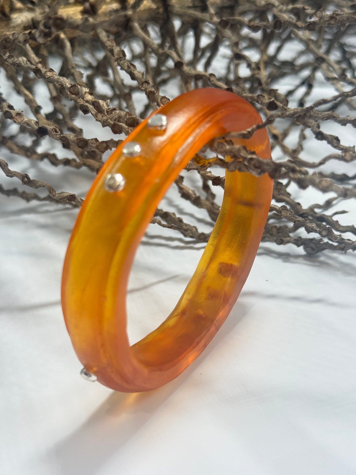 Translucent Burnt Orange resin rim bangle with sterling silver rivets